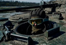 A Ukrainian soldier looks out a passing APC on the frontline in Bakhmut, Donetsk region, Ukraine, Monday, April 10, 2022