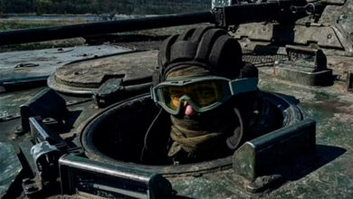 A Ukrainian soldier looks out a passing APC on the frontline in Bakhmut, Donetsk region, Ukraine, Monday, April 10, 2022