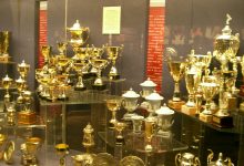Manchester City and Manchester United logos on a football pitch