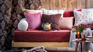 Purple cushions on a day bed with wooden wall panelling and grey carpet