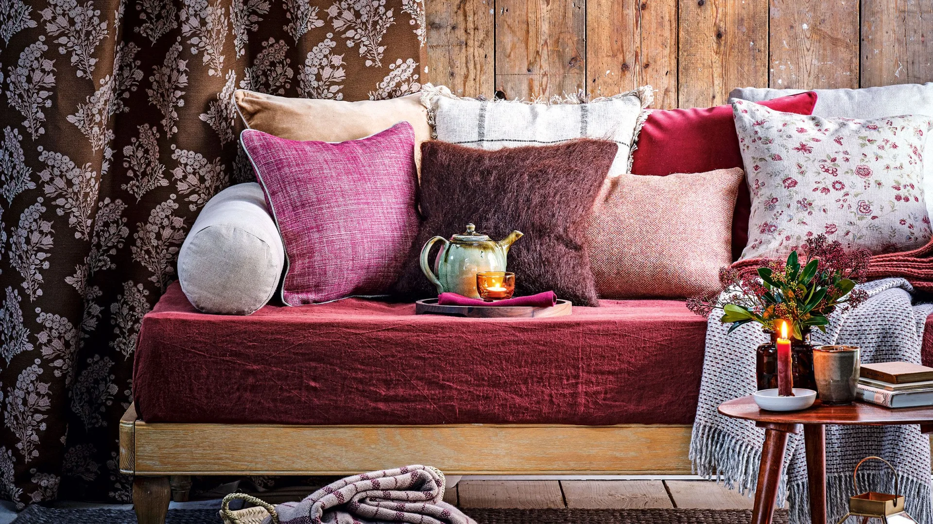 Purple cushions on a day bed with wooden wall panelling and grey carpet