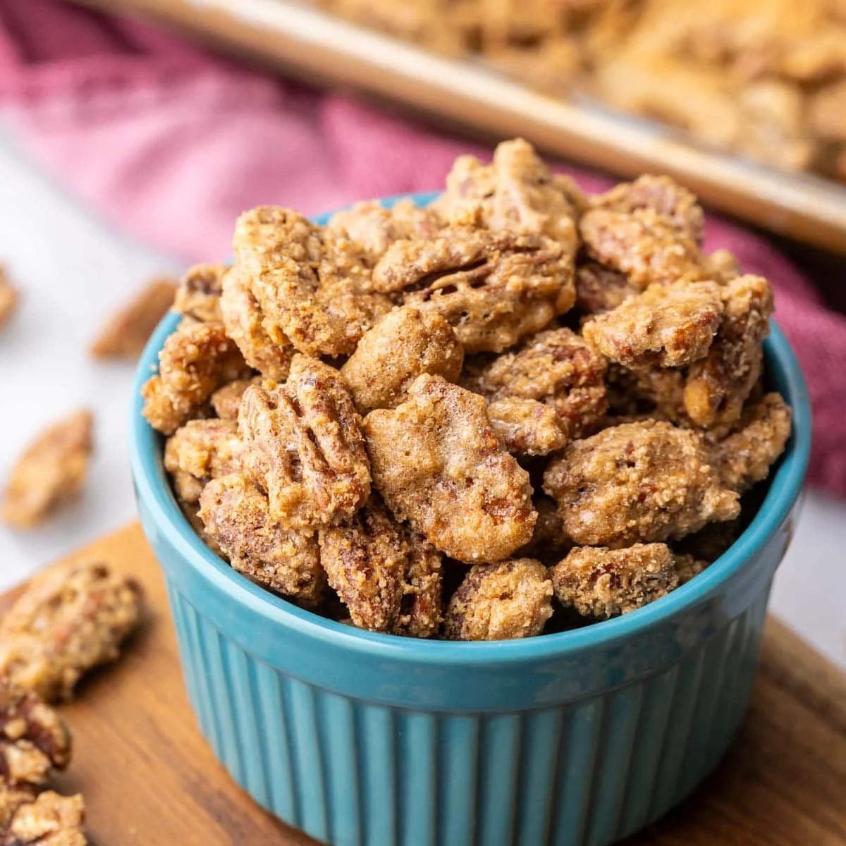 Close-up view of a blue ramekin filled with candied pecans.