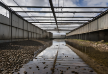 AI-generated image: The image shows a long, industrial building with a corrugated metal exterior.