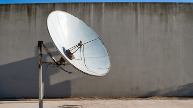 AI-generated image: A satellite dish is mounted on a metal pole against a gray concrete wall.