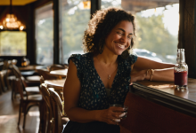 AI-generated image: A woman with curly dark hair is sitting on a bar counter in a dimly lit interior.