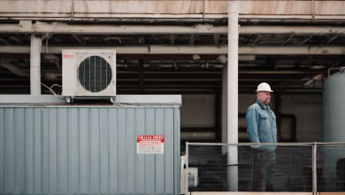 AI-generated image: The image shows a man wearing a white hard hat and denim jeans standing on a metal platform.