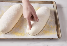 Finger poking a loaf of proofing bread dough
