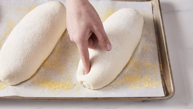 Finger poking a loaf of proofing bread dough