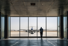 AI-generated image: The image shows a man in a dark-colored shirt and pants standing in a modern airport terminal.