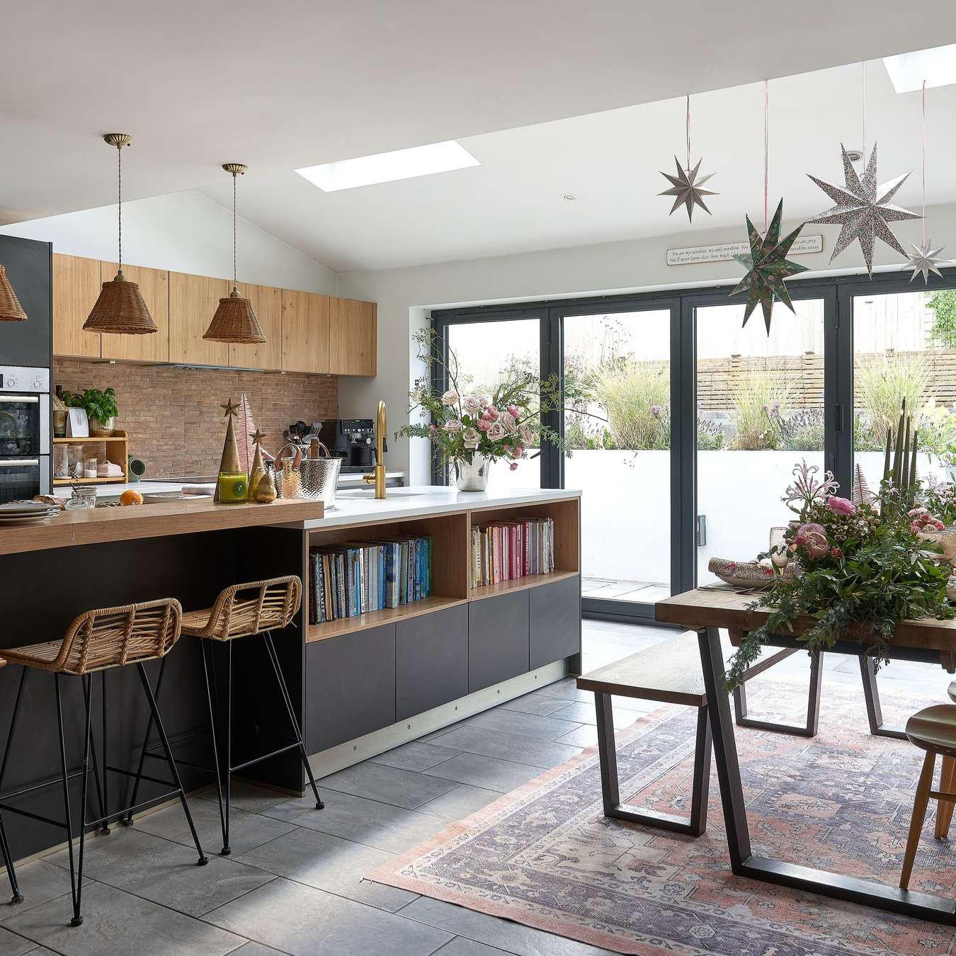 Kitchen decorated for kitchen with hanging starts and full size silver christmas tree.